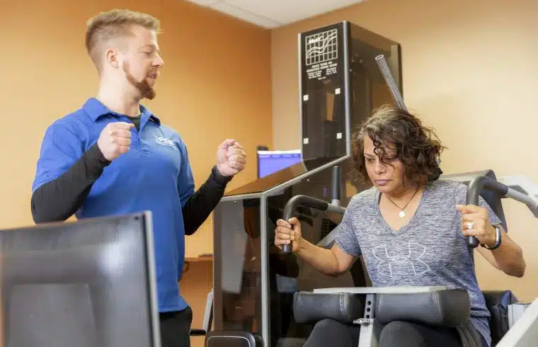 MedX Equipment iSpine patient being trained by physical therapist to use medx equipment