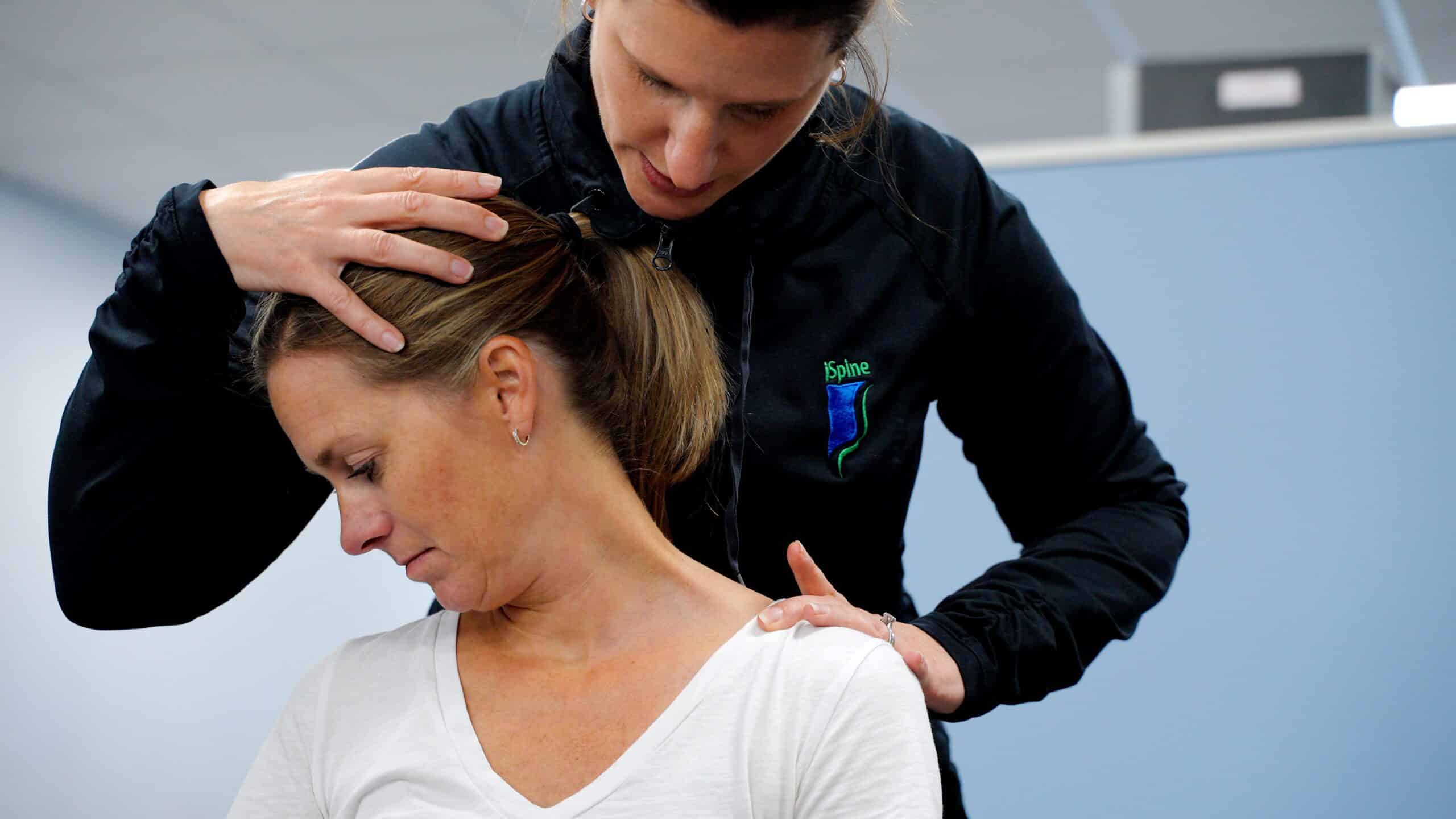 iSpine Rehab therapist doing a manual neck stretch on a patient