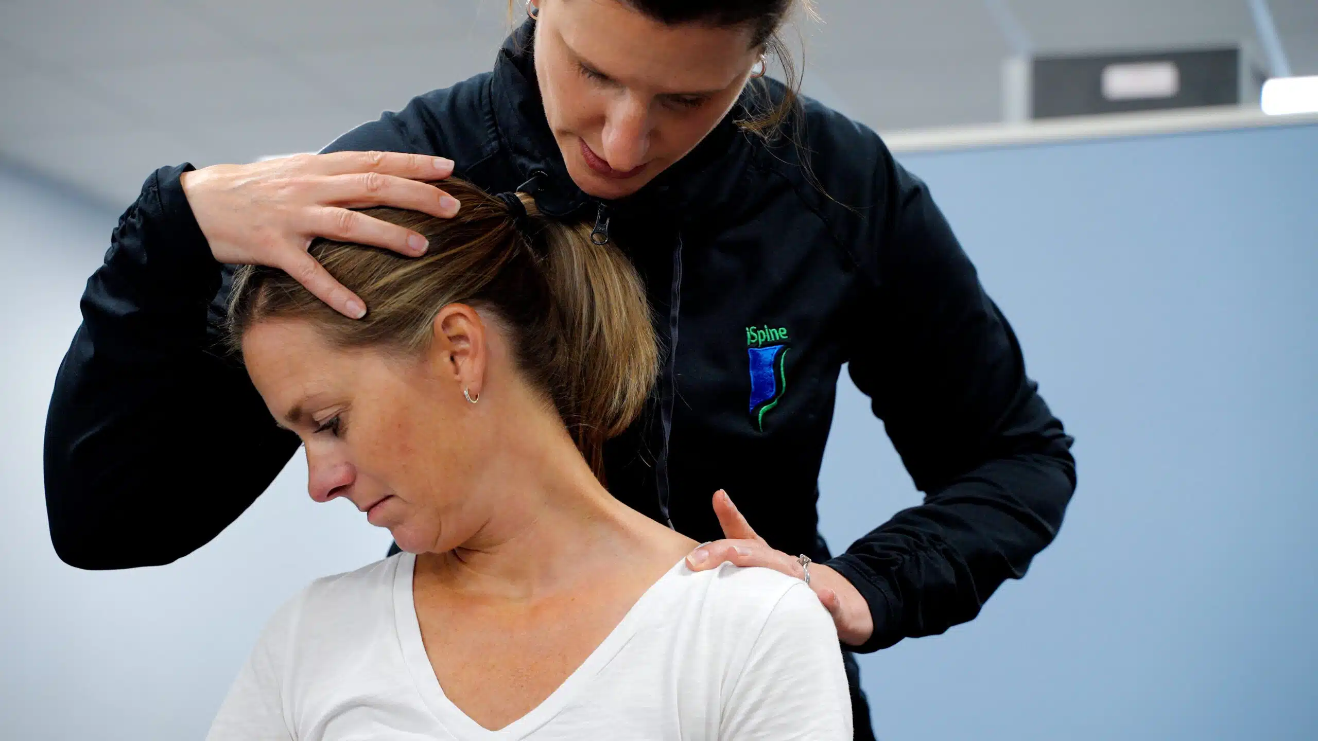 iSpine Rehab neck stretch iSpine Rehab therapist doing a manual neck stretch on a patient