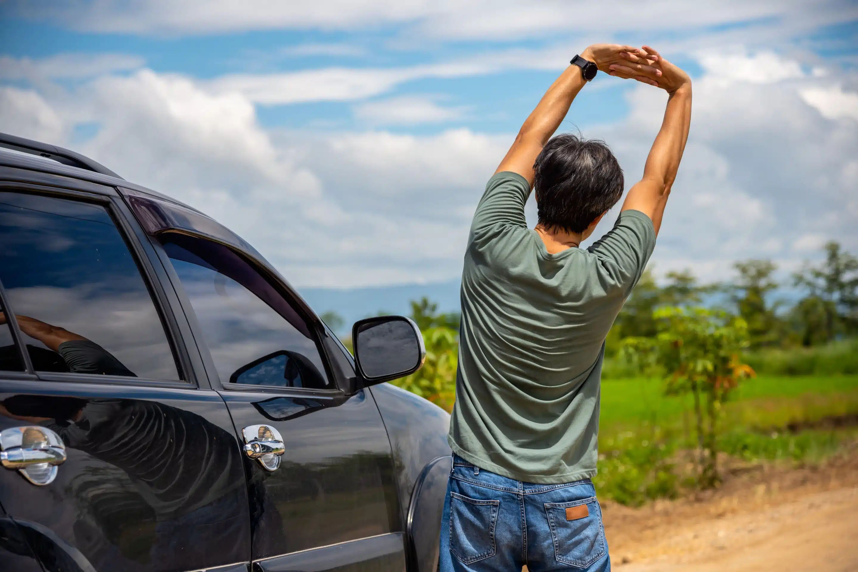 man stretching while on a road trip