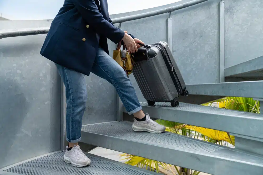 Woman struggling with heavy suitcase
